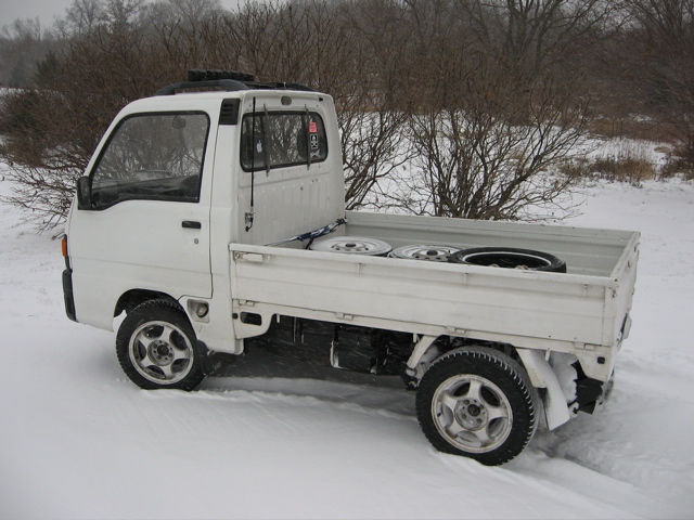 1990 Subaru Sambar kei truck parked in deep snow