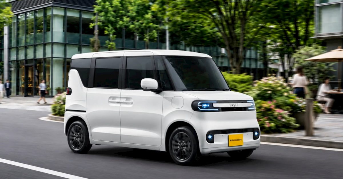 White BYD Racco kei EV driving on a tree lined Japanese street