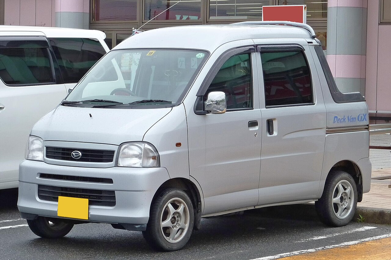 A silver ninth generation Daihatsu Hijet Deck Van GX from the front, showing the semi cab nose and the short open deck behind the rear doors